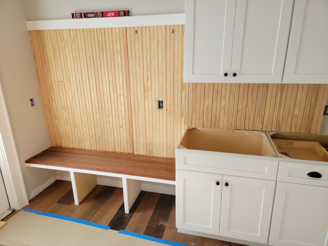 Mudroom bench with vertical wood paneling